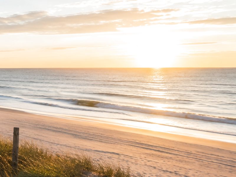 KI-generiertes Stimmungsbild eines Strandes bei Abendsonne — zeigt nicht den genannten Ort