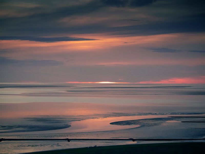 Abendrot über dem Wattenmeer vor Büsum, das Licht spiegelt sich in den nassen Wattflächen